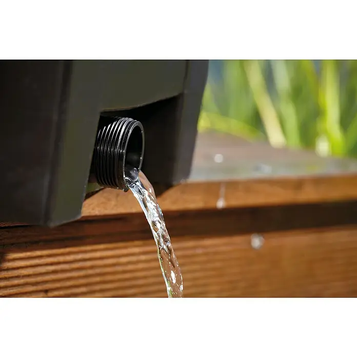 Oase Durchlauffilter BioSmart Set 7000 - 40 W, Teichgröße: 7 m³ - Nahaufnahme eines schwarzen Wasserbehälters mit Wasser, das aus einem Auslass fließt. Der Behälter steht auf einer Holzoberfläche.