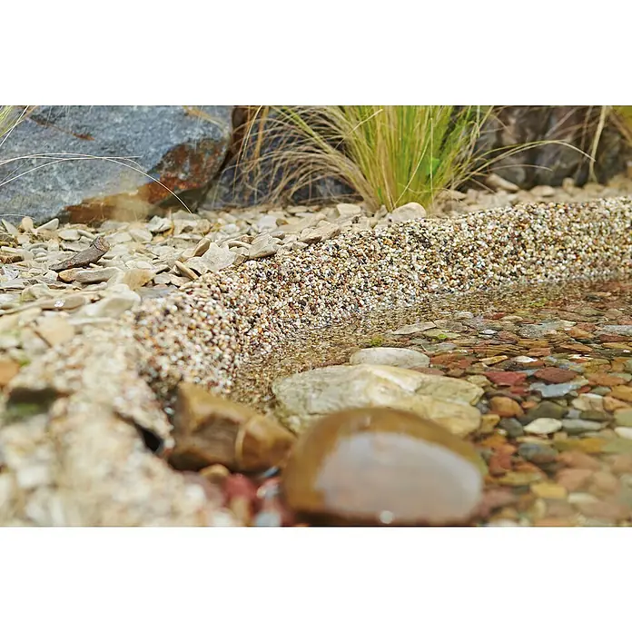 Oase Steinfolie Meterware - Breite: 1 m, Stärke: 0,5 mm - Bachbett mit Steinen und Kies. Das klare Wasser fließt über die bunten Steine und den feinen Kies am Ufer, umgeben von Vegetation.