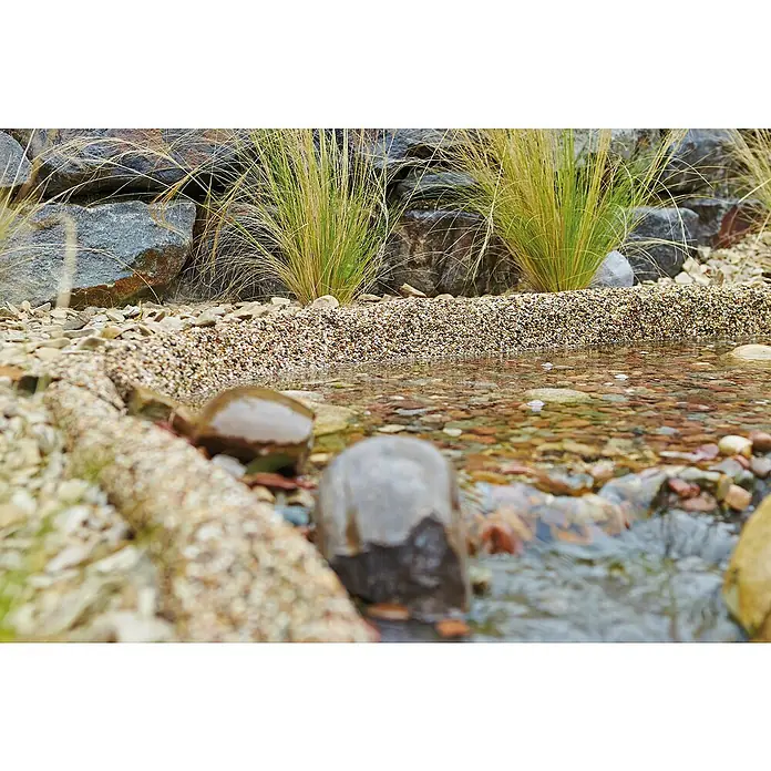 Oase Steinfolie Meterware - Breite: 1 m, Stärke: 0,5 mm - Steine und Pflanzen am Ufer eines klaren Bachs, der über Steine fließt.