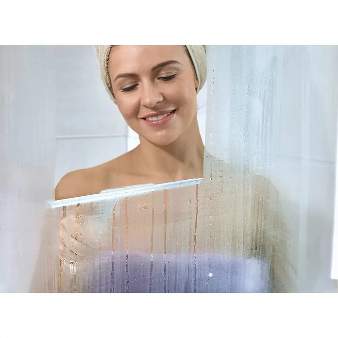 Leifheit Bad-& Duschabzieher Cabino Showerslider - Weiß, Kunststoff - Eine Frau mit einem Handtuch auf dem Kopf reinigt mit einem Abzieher eine beschlagene Duschwand, um sie sauber und klar zu halten.