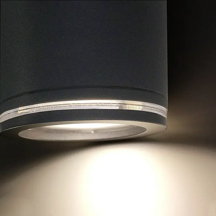 Steinel LED-Sensor-Außenwandleuchte Spot Duo S anthrazit - 14,95 W, L x B x H: 9,8 x 24,7 x 17,5 cm, Anthrazit, Warmweiß - Nahaufnahme einer stilvollen schwarzen Downlight-Leuchte mit silberfarbenen Akzenten, die ein helles, nach unten gerichtetes Licht erzeugt.