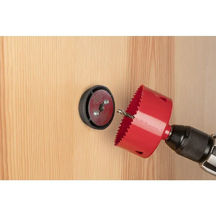Wolfcraft Aufbohrhilfe für Lochsägen - Durchmesser: 35 mm - 51 mm - Eine rote Lochsäge an einer Bohrmaschine, die auf ein Holzstück mit einer schwarzen Führungsscheibe ausgerichtet ist.
