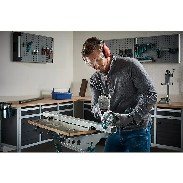 Wolfcraft Trennscheibe - Geeignet für: Aluminium, Durchmesser: 125 mm, Bohrung: 22,22 mm - Ein Mann sägt ein Metallrohr mit einer Trennscheibe. Er trägt Schutzkleidung wie Schutzbrille und Ohrenschützer.