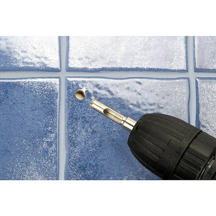 Wolfcraft Hohlbohrkrone Ceramic - Schnitttiefe: 30 mm - Nahaufnahme einer Bohrmaschine mit Diamantbohrer, die ein Loch in blaue Keramikfliesen bohrt. Präzises Werkzeug für Fliesenbearbeitung.