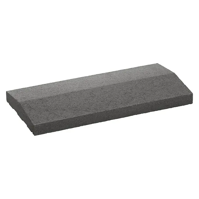 Mauerabdeckplatte Satteldach - Anthrazit, 50 x 25 cm, Beton - Nahaufnahme eines grauen Pflastersteins mit abgeschrägten Kanten auf schwarzem Hintergrund. Ideal für Garten- und Landschaftsbauprojekte.