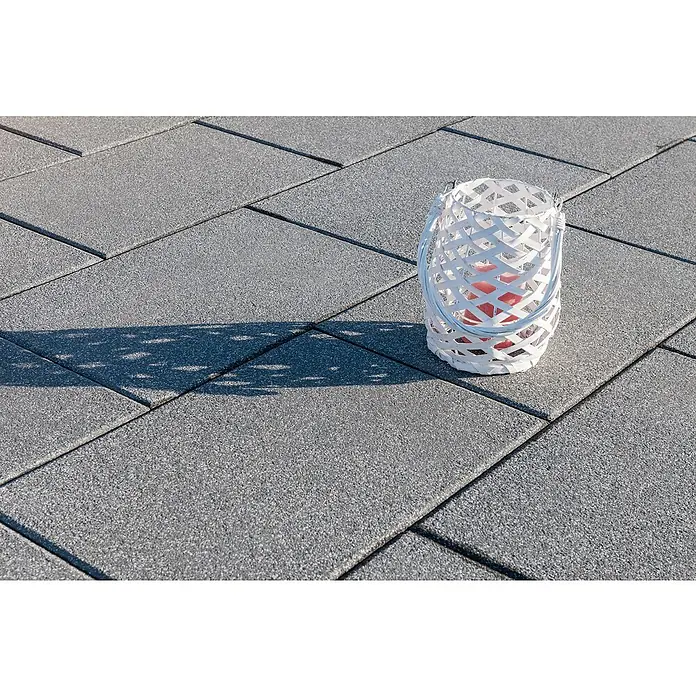 Diephaus Terrassenplatte Norfolg - 40 x 40 x 4 cm, Basalt, Beton - Außenaufnahme einer weißen Laterne auf Pflastersteinen, die ein sanftes, warmes Licht abstrahlt.