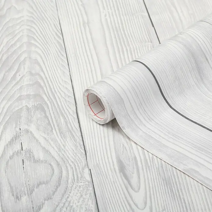 D-c-fix Holzoptikfolie Shabby Wood - 200 x 45 cm, Weiß, Selbstklebend - Nahaufnahme einer Rolle grauer Holzmaserung-Klebefolie auf einem weißen Holzhintergrund, perfekt für DIY-Projekte und zur Dekoration von Möbeln.