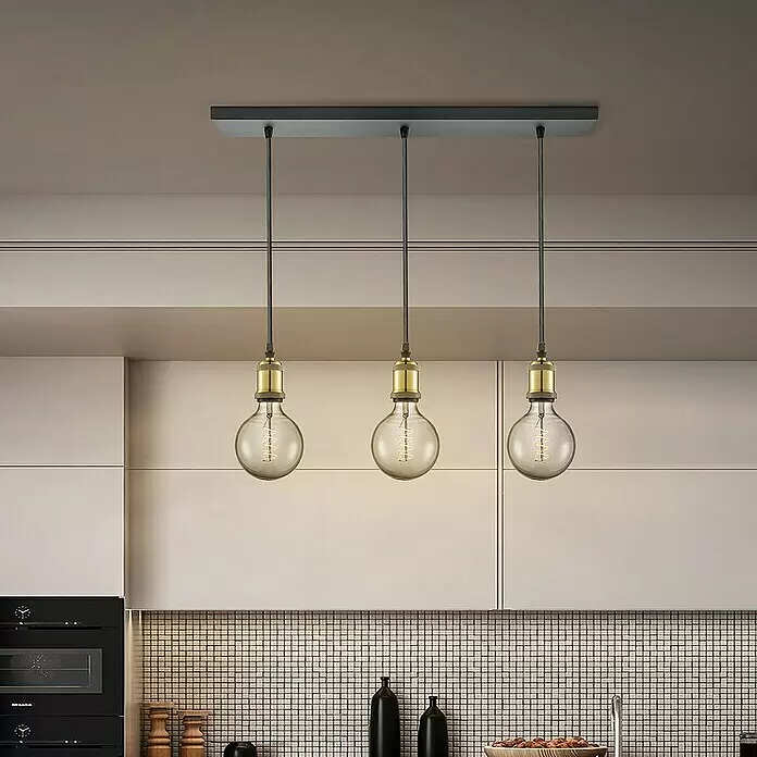 Home Sweet Home Textilkabel Meterware Online - Schwarz, 3, 0,75 mm² - Drei industrielle Pendelleuchten mit Messingakzenten und kugelförmigen Edison-Glühbirnen, an einer schwarzen Rechteckplatte über Küchenzeile hängend.