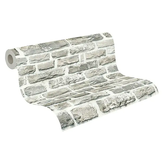 A.S. Création Elements Vliestapete Steine - Creme/Grau, Steinoptik, 10,05 x 0,53 m - Eine Rolle grauer Steinmauer-Tapete wird ausgerollt und zeigt das realistische Design und die Textur der Steine.