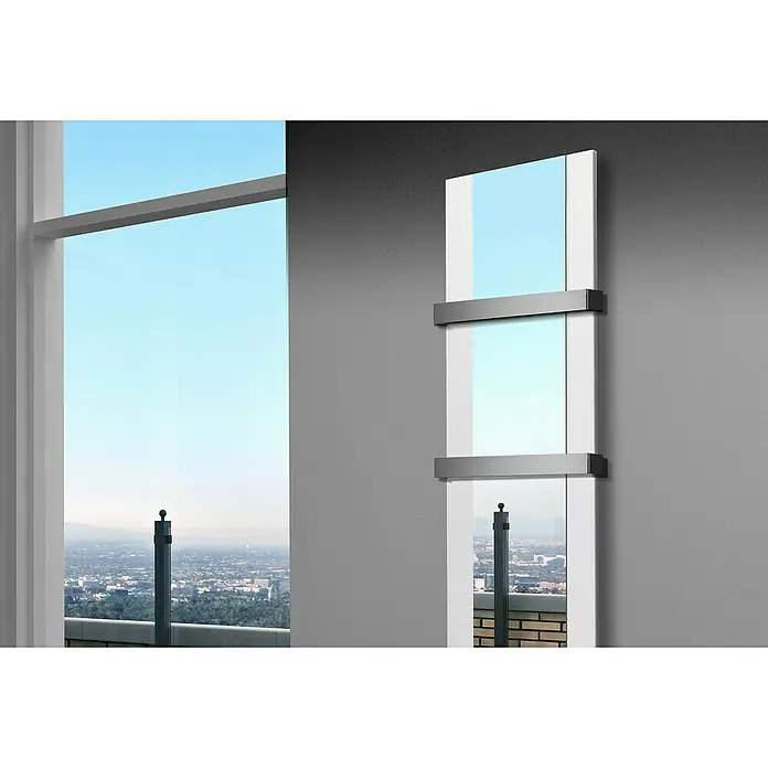 Szagato Designheizkörper Singapur - B x H: 470 x 1.800 mm, Weiß, Mit 2 Handtuchhalter (50 mm) - Ein moderner, dreiteiliger Spiegel mit grauen Akzenten hängt an einer grauen Wand und reflektiert eine Skyline durch ein Fenster.