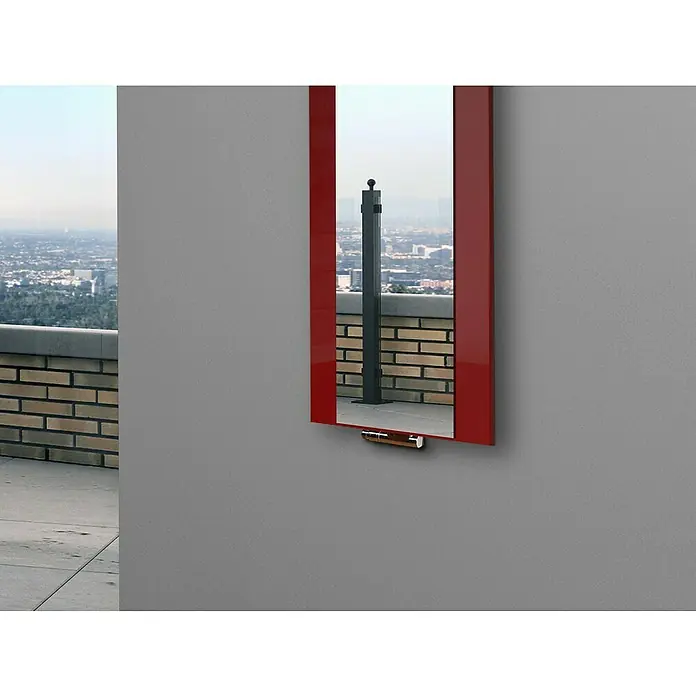 Szagato Designheizkörper Singapur - B x H: 470 x 1.200 mm, Wärmeleistung bei Vorlauftemperatur von 75 °C (D: 50): 799 W, Rot, Mit 1 Handtuchhalter (15 mm) - Ein roter Spiegel hängt an einer grauen Wand und reflektiert eine Dachterrasse mit Geländer und Stadtblick. Der Spiegel verleiht dem Raum Tiefe.