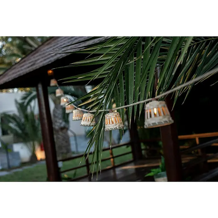 New Garden Solar-Lichterkette Aurora - Länge: 8 m, IP44 - Stimmungsvolle Außenbeleuchtung mit einer Lichterkette aus kleinen, glockenartigen Lampen, die an einem Palmenzweig befestigt sind.