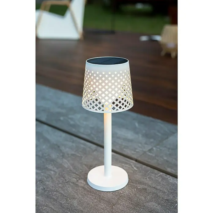 New Garden Lámpara decorativa solar Greta - 0,5 W, Blanco, IP65 - Primer plano de una elegante lámpara solar blanca con una pantalla decorativa con motivos de celosía sobre una superficie gris.