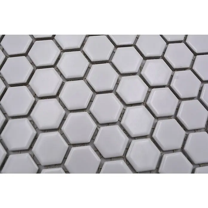 Mosaikfliese Hexagon Uni HX 055 - 26 x 30 cm, Weiß, Matt - Nahaufnahme von weißen, sechseckigen Keramikfliesen, die ein sauberes und modernes Muster bilden. Ideal für Badezimmer oder Küchen.