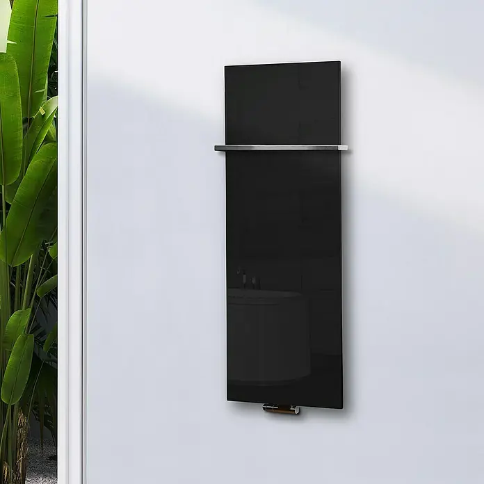 Szagato Designheizkörper Montevideo - B x H: 470 x 1.200 mm, Wärmeleistung bei Vorlauftemperatur von 75 °C (D: 50): 799 W, Schwarz, Mit 1 Handtuchhalter (15 mm) - Abbildung eines modernen, schwarzen Glasheizkörpers mit Handtuchhalter an einer weißen Wand. Minimalistisches Design für Badezimmer.