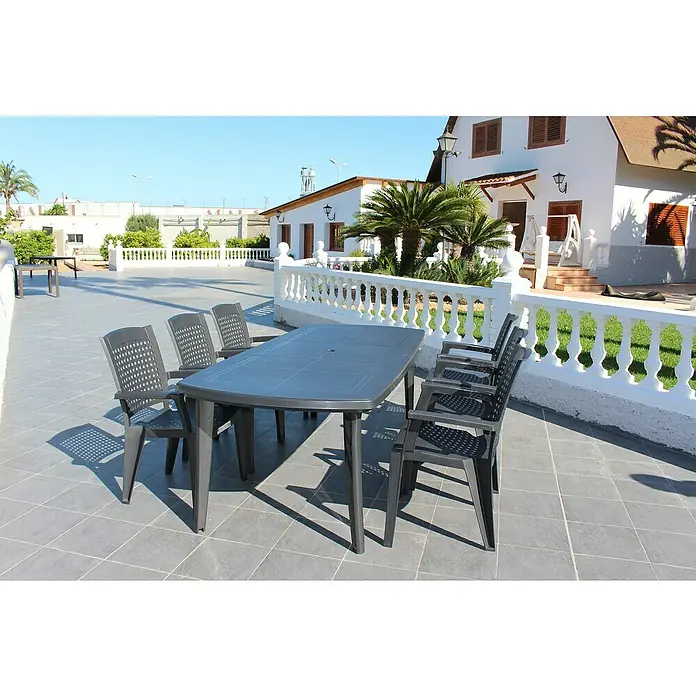 Silla de jardín Atlantic - 59 x 60 x 87 cm, Antracita, Polipropileno, Apilable - Una mesa de jardín gris con seis sillas ubicada en un patio, perfecta para comer al aire libre con familiares y amigos.
