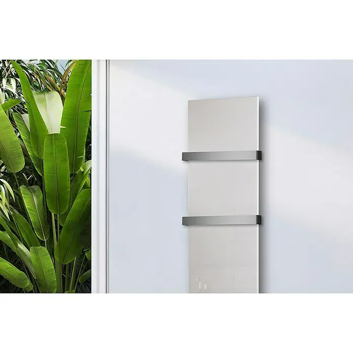 Szagato Designheizkörper Montevideo - B x H: 470 x 1.800 mm, Weiß, Mit 2 Handtuchhalter (50 mm) - Ein moderner, weißer Handtuchwärmer mit zwei silbernen Halterungen ist an einer weißen Wand neben einer Fensterfront mit Pflanzen befestigt.