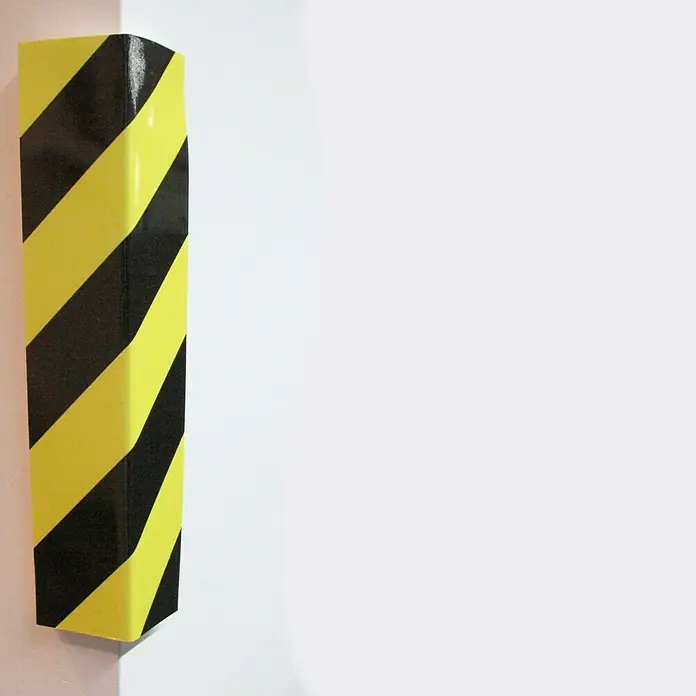 Banda de gomaespuma para esquinas ADH - 40 x 15 cm, Amarillo/Negro - Protector de esquina de rayas negras y amarillas en una pared. La protección de advertencia garantiza la seguridad y reduce el riesgo de lesiones.