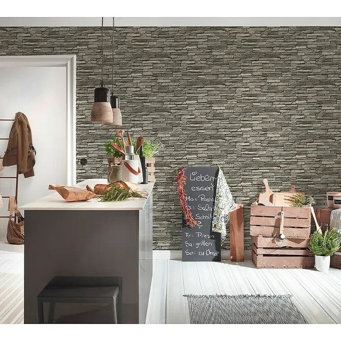A.S. Création Elements Vliestapete Bruchsteinmauer - Grau/Creme, Steinoptik, 10,05 x 0,53 m - Einladende Küchendekoration mit Tafel, auf der das Menü geschrieben steht, rustikalen Holzkisten und einer modernen Kücheninsel.