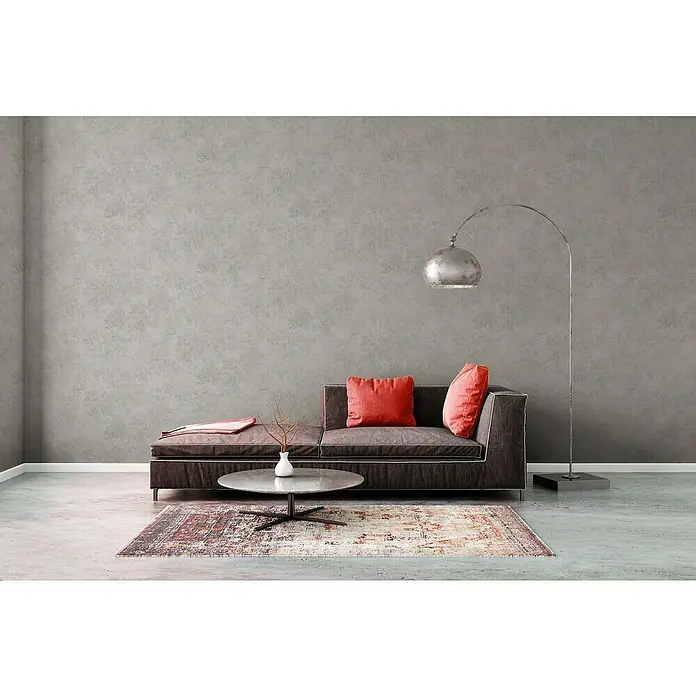 A.S. Création Elements Vliestapete - Grau, Betonoptik, 10,05 x 0,53 m - Elegantes Wohnzimmer mit stilvollem Sofa, dekorativen Kissen und einer modernen Stehlampe für eine gemütliche Atmosphäre.