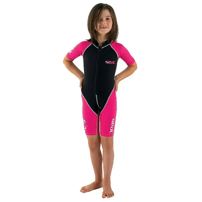 Seac Sub Traje de neopreno Shorty - 9 años, Plástico, Apto para: Niños, Negro/Rosa - Niña con un sotovestido SEAC, perfecto para deportes acuáticos. El traje es negro y rosa con mangas y piernas cortas, ideal para nadar.