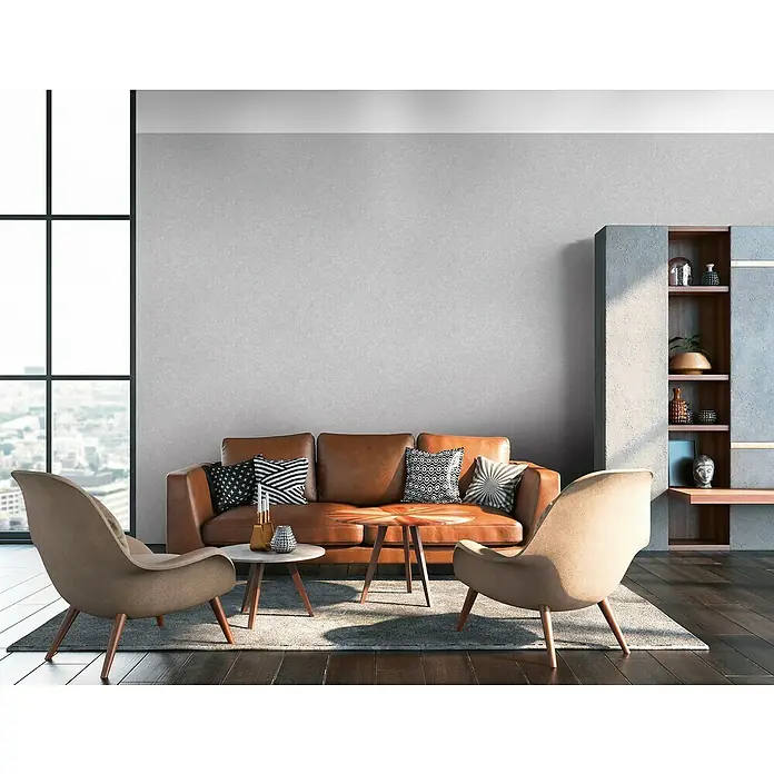 A.S. Création Industrial Vliestapete - Mittelgrau, Uni, 10,05 x 0,53 m - Dieses Bild zeigt ein modernes Wohnzimmer mit einem eleganten braunen Sofa, zwei Sesseln und stilvollen Möbeln, die eine gemütliche Atmosphäre schaffen.