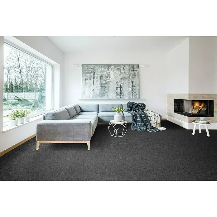 Teppichboden Meterware Nele - Breite: 400 cm, Frisée, 100 % Polypropylen (Flor), Dunkelgrau - Elegantes Wohnzimmer mit dunklem Teppichboden, grauer Eckcouch und modernem Kamin. Der Teppich sorgt für Wärme und Komfort im Raum.