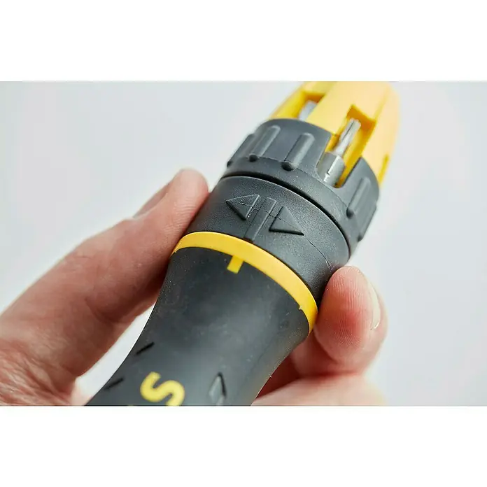 Stanley Destornillador de punta intercambiable 0-68-010 - 10 pzs. - Primer plano de un destornillador con portabits y mango negro, sostenido por una mano. Acentos amarillos decoran el destornillador.
