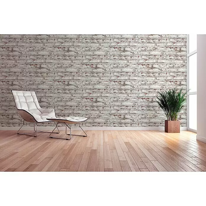 A.S. Création Elements Vliestapete Backsteinmauer - Weiß/Braun/Grau, Steinoptik, 10,05 x 0,53 m - Eleganter weißer Tufted-Sessel und passender Hocker mit Chromfüßen, in einem Raum mit Ziegelwand und Holzfußboden.