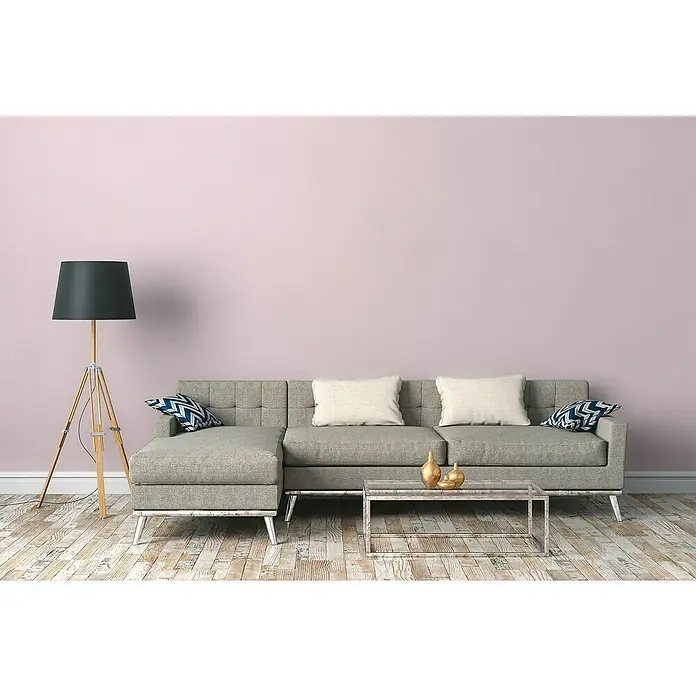 A.S. Création New Life Vliestapete - Rosa, Uni, 10,05 x 0,53 m - Ein modernes Wohnzimmer mit grauem Sofa, Stehlampe und minimalistischem Couchtisch vor einer zartrosa Wand.