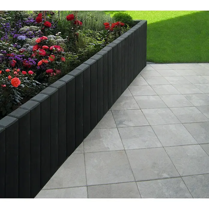 Diephaus Rechteckpalisade - 16,5 x 12 x 200 cm, Anthrazit, Beton - Der erhöhte Gartenbereich mit einer schlichten, dunklen Steinmauer und hellgrauen Bodenfliesen schafft eine moderne Gartengestaltung.