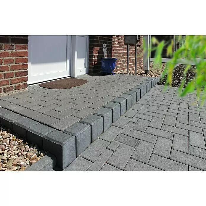 Diephaus Rechteckpalisade - 16,5 x 12 x 40 cm, Grau, Beton - Außenbereich mit grauen Betonpflastersteinen, dunkle Randsteine säumen den Weg zum Eingang.