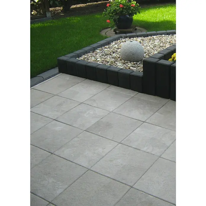 Diephaus Rechteckpalisade - 16,5 x 12 x 60 cm, Anthrazit, Beton - Außenaufnahme eines grauen, gepflasterten Hofes mit Steinen und einer dekorativen Kugel, umrandet von dunklen Ziegeln.