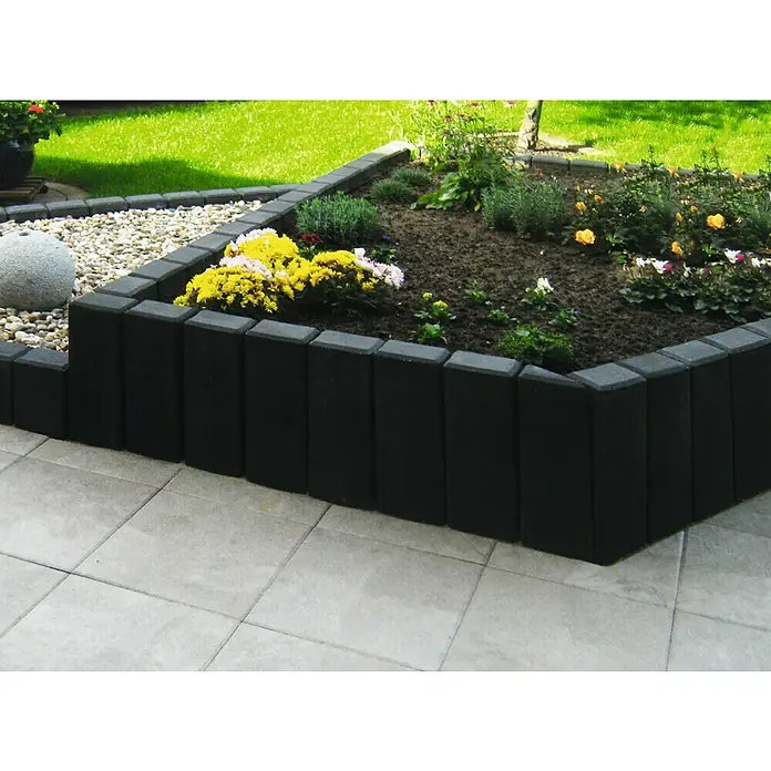 Diephaus Rechteckpalisade - 16,5 x 12 x 100 cm, Anthrazit, Beton - Das Bild zeigt eine dekorative Garteneinfassung aus schwarzen Steinen, die ein Blumenbeet mit blühenden Pflanzen und einen Kiesbereich umrandet.