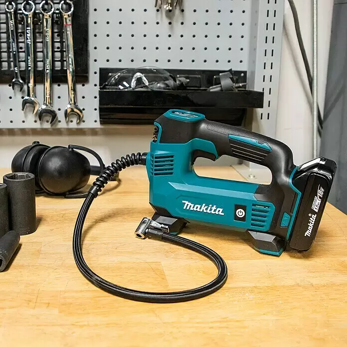 Makita LXT 18V Akku-Kompressor DMP180Z - 18 V, Ohne Akku, 8,3 bar - Türkis-schwarzer Makita 18V Akku-Inflator mit Schlauch und Metallventilanschluss auf einer Holzwerkbank.