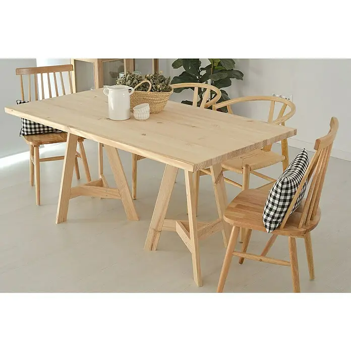 Astigarraga Encimera - Pino, 140 cm x 70 cm x 30 mm - Una mesa de comedor de madera clara con sillas a juego, decorada con una jarra blanca y una cesta, irradia encanto rústico.