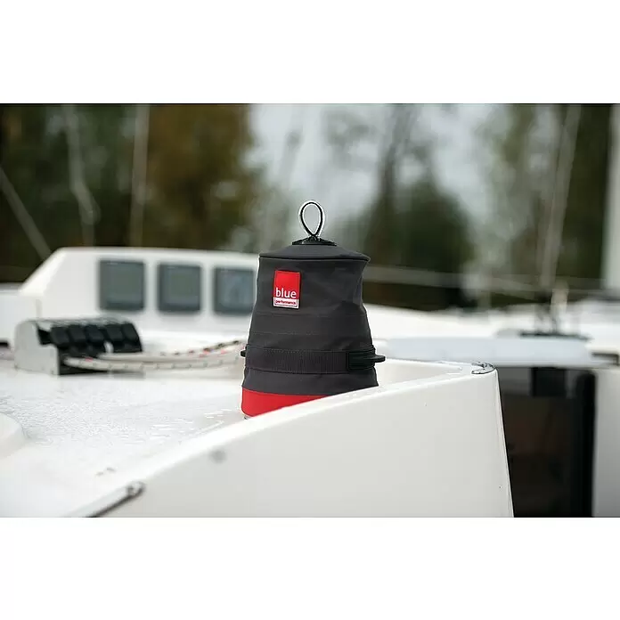 Blue Performance Windenabdeckung - Ø x H: 173 x 165 mm, Schwarz/Rot - Dunkelgraue Winchabdeckung mit rotem Rand und Metallschlaufe, schützt eine Winch auf einem Bootsdeck.