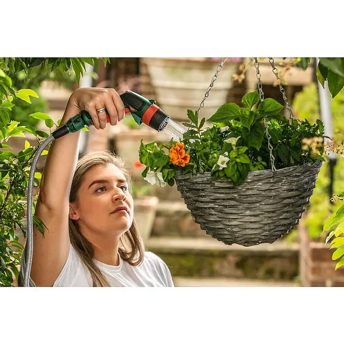 Bosch Power for All 18V Akku-Hochdruckreiniger Fontus - 18 V, 1 Akku, Max. Druck: 20 bar - Eine Frau gießt eine Hängeampel mit einem grünen Wasserschlauch mit Sprühkopf, um die Blumen zu bewässern.