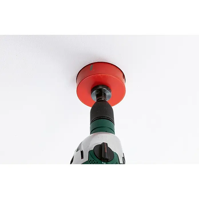 Paulmann Panel LED redondo Veluna - 17 W, Ø x Al: 18,5 x 3,1 cm, Satin, Blanco cálido, No regulable - Un accesorio de sierra de agujero rojo está fijado a un taladro sujeto contra un techo blanco para perforar un agujero.