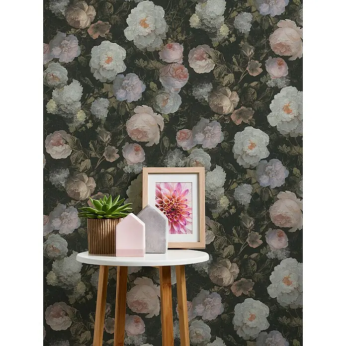 A.S. Création History of Arts Vliestapete Blumen - Rosa/Weiß/Grün, Floral, 10,05 x 0,53 m - Nahaufnahme eines kleinen, weißen Beistelltischs mit einer Sukkulente, einem Fotorahmen und dekorativen Häusern vor einer floralen Tapete.