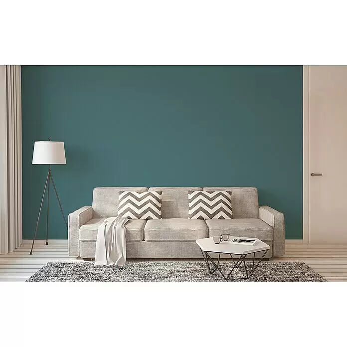 A.S. Création New Life Vliestapete I - Petrol, Uni, 10,05 x 0,53 m - Helles graues Stoffsofa mit Zierkissen und einer Decke, arrangiert für ein modernes Wohnzimmer.