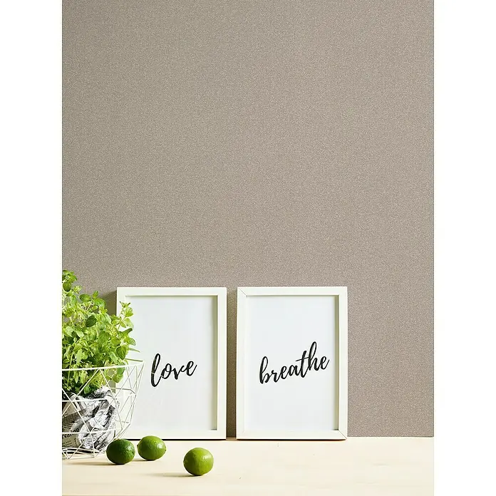 A.S. Création New Elegance Vliestapete - Braun, Uni, 10,05 x 0,53 m - Nahaufnahme von gerahmten 'Liebe' und 'Atmen' Wandkunstwerken mit einer Topfpflanze und Limetten, die ein ruhiges und dekoratives Ambiente ausstrahlen.