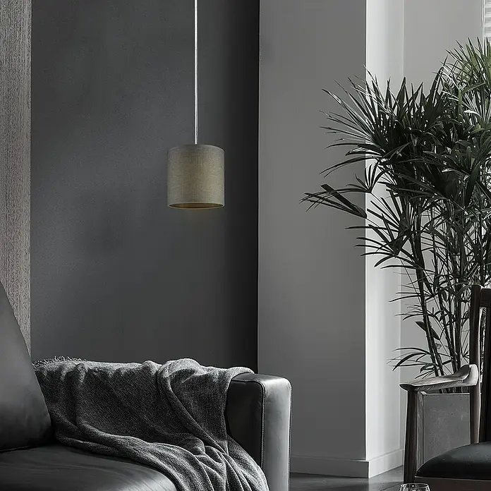 Home Sweet Home Lampenschirm Canvas - 16 cm, Sturmgrau, Baumwolle, Rund - Nahaufnahme einer grauen zylindrischen Pendelleuchte, die über einem Ledersofa mit einer grauen Decke hängt. Elegantes Interieur mit Pflanze.