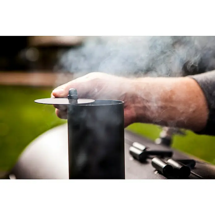 Char-Broil Smoker Oklahoma Joe - Grillfläche (B x T): 88 x 44 cm - Rauch steigt aus dem schwarzen BBQ-Smoker, während eine Hand den Deckel hält. Perfekt zum langsamen Garen von Fleisch.
