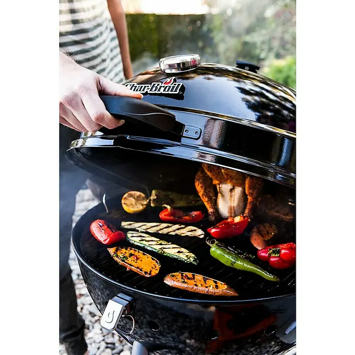 Char-Broil Kugelgrill Kettleman - Durchmesser Grillfläche: 52 cm, Schwarz - Ein Char-Broil-Grill mit geöffnetem Deckel, der eine Vielzahl von gegrilltem Gemüse und ein ganzes Hähnchen zeigt.