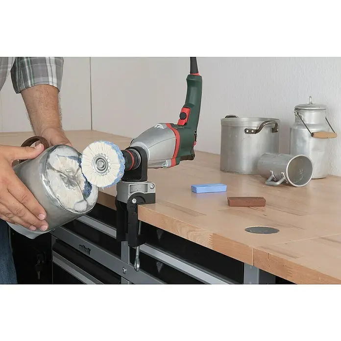 Wolfcraft Polier-Set - Gesamtumfang: 6 -tlg. - Eine Werkstatt-Szene mit einer Poliermaschine, die an einer Werkbank befestigt ist, und einem Mann, der einen Behälter poliert.