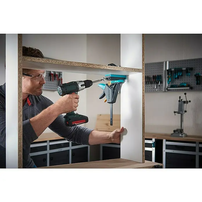 Wolfcraft Werkzeugkoffer Undercover Jig - 54 -tlg. - Ein Mann arbeitet mit einer Wolfcraft Einhandzwinge und einem Akkuschrauber an einem Holzregal. Das Werkzeug ist hochwertig und präzise.