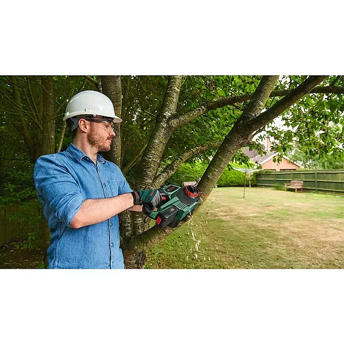 Bosch Power for All 18V Akku-Kettensäge UniversalChain 18 - 18 V, Li-Ionen, 1 Akku, Schwertlänge: 20 cm - Ein Mann benutzt eine Bosch Akku-Astsäge, um einen Baumast zu schneiden. Er trägt Schutzkleidung für sicheres Arbeiten im Garten.