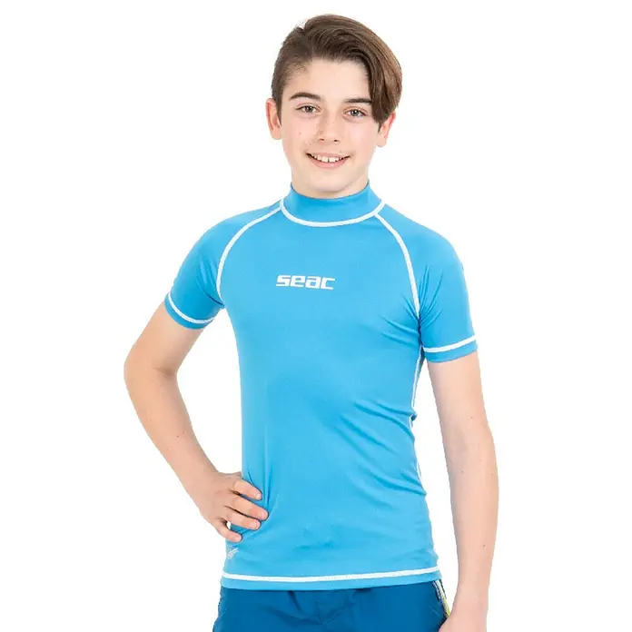 Seac Sub Camiseta térmica T-Sun Short - Apto para: Niños, 7 años, Azul - Imagen de un niño que lleva una camiseta de manga corta SEAC en azul claro con detalles blancos y un logotipo de SEAC.
