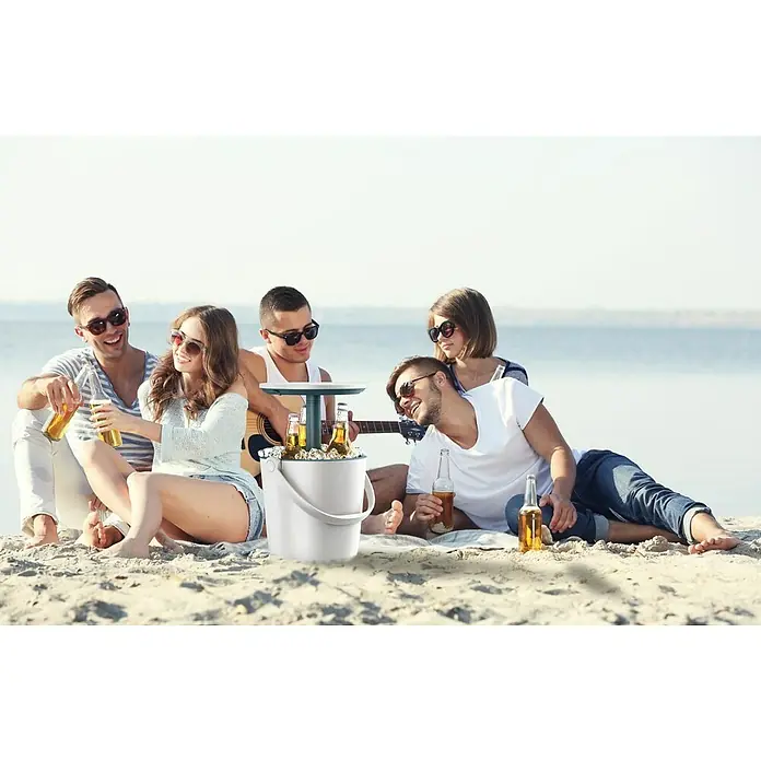 Keter Mesa alta de jardín redonda Go Bar - L x An x Al: 38 x 38 x 37 cm, Blanco - Escena de playa con un grupo de amigos reunidos alrededor de un cubo refrigerador multifuncional con función de mesa.
